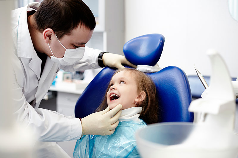dentist inspecting child's mouth